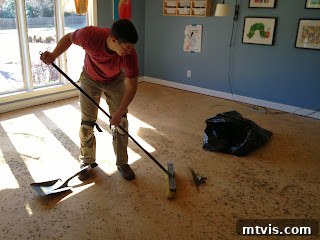The Ultimate Playroom Unveiled 8 Subfloor after carpet removal, showing the messy DIY process