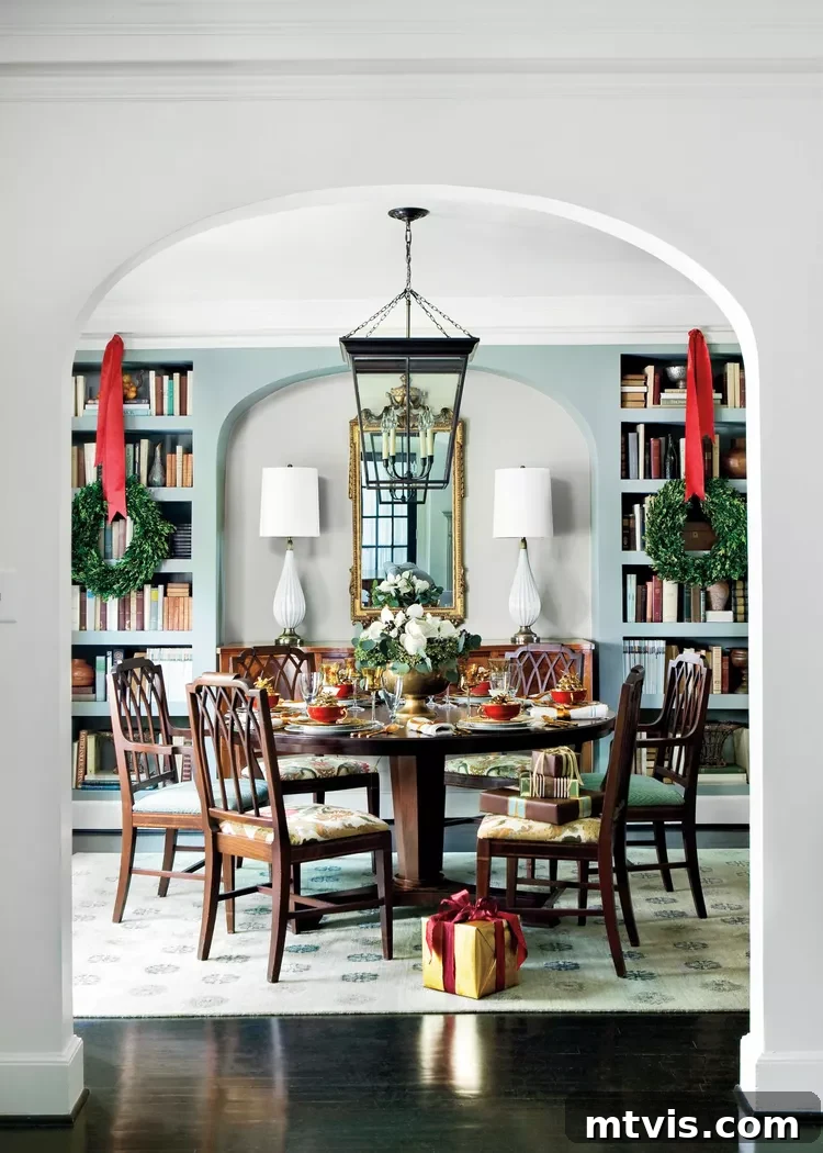 Elegant dining room featuring built-in bookcases adorned with charming Christmas wreaths suspended by ribbons.