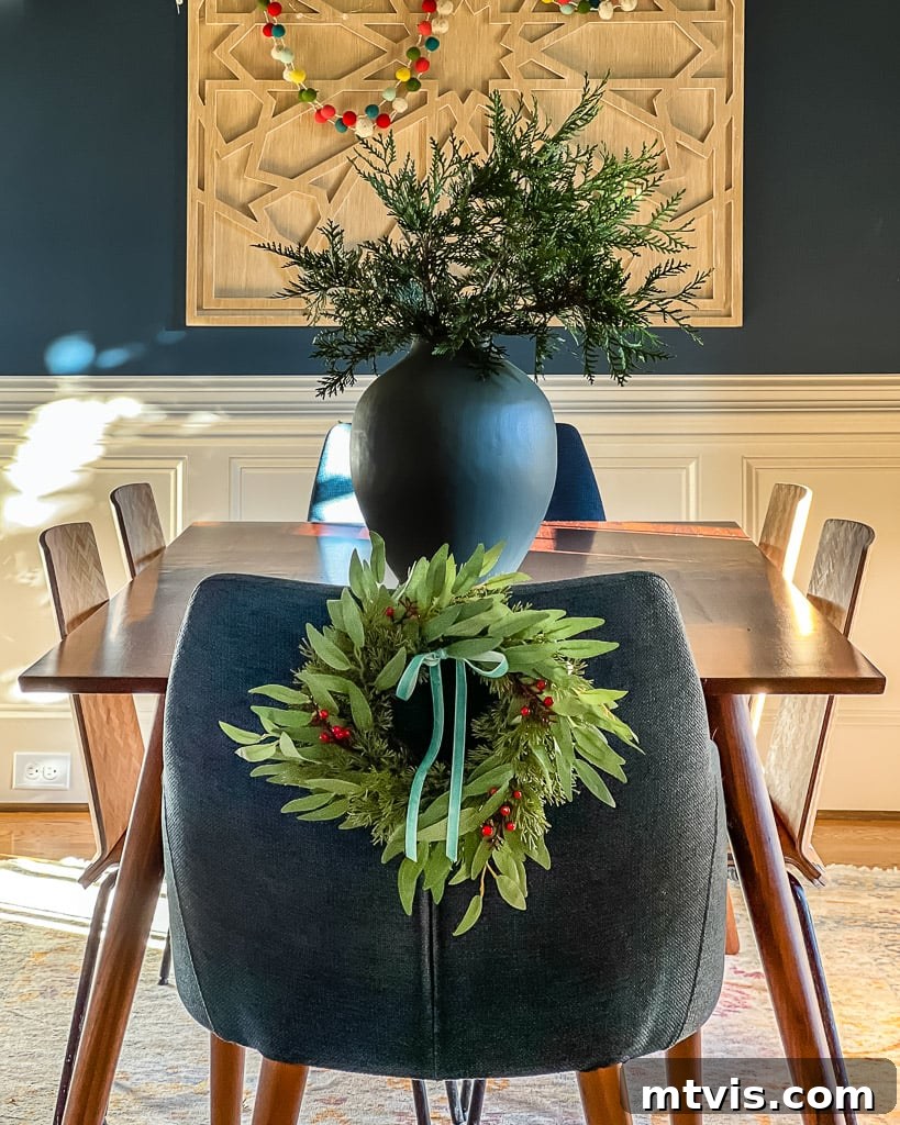 Mini wreaths elegantly tied to dining room chairs, enhancing the Christmas decor.
