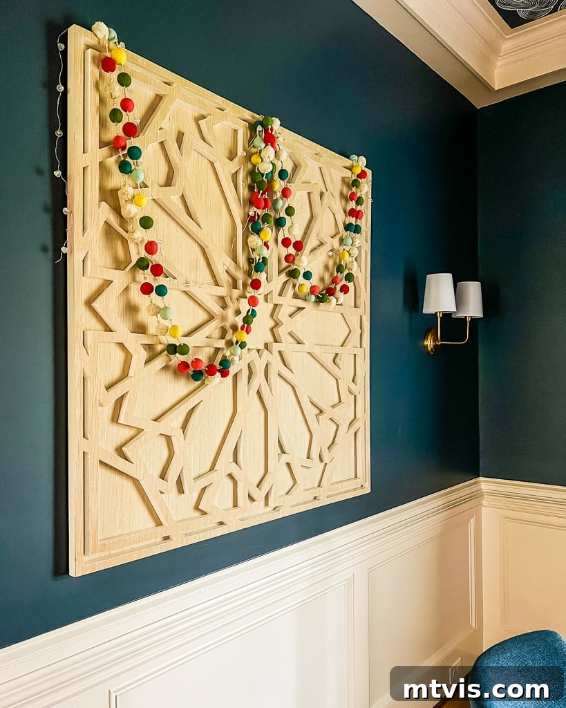 Simple yet elegant Christmas decorations adorning a dining room, featuring a festive garland with lights draped over wall art.