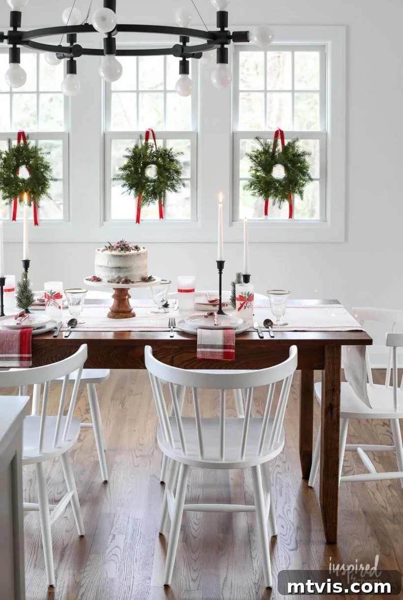 Light and airy dining room elegantly decorated for Christmas, featuring wreaths adorning the windows for a clean and simple look.