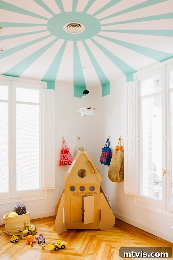 Playful and Chic Playroom Design Guide 14 One playroom idea shows a ceiling made to look like a circus tent, along with a cardboard rocket ship and bags in the corner.