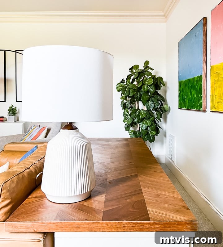 Playful and Chic Playroom Design Guide 15 A wooden tabletop with a white lamp is behind a leather couch and is used as a desk for kids.
