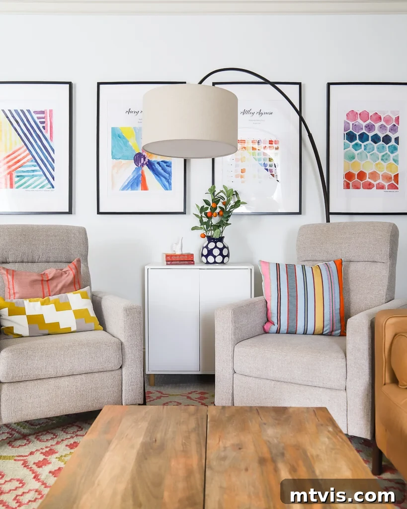 Playful and Chic Playroom Design Guide 26 Two comfortable chairs, white cabinet, and a wood coffee table are in front of a wall of framed children's artwork.
