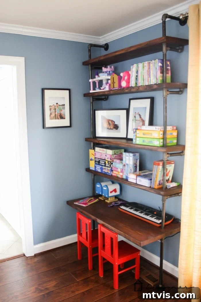 Playful and Chic Playroom Design Guide 5 The corner of a playroom with pipe bookshelves and a shelf-desk. Books and games are neatly arranged on the dark wood shelves.