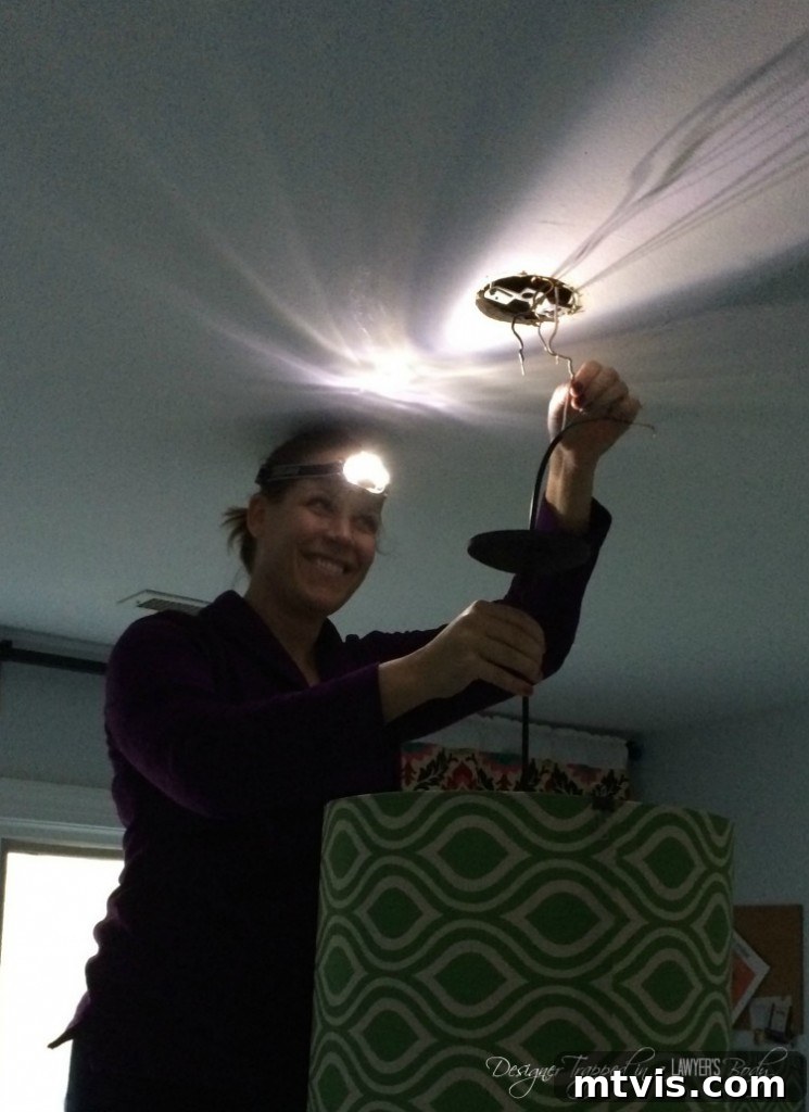 DIY enthusiast installing a new custom fabric pendant light in a craft room