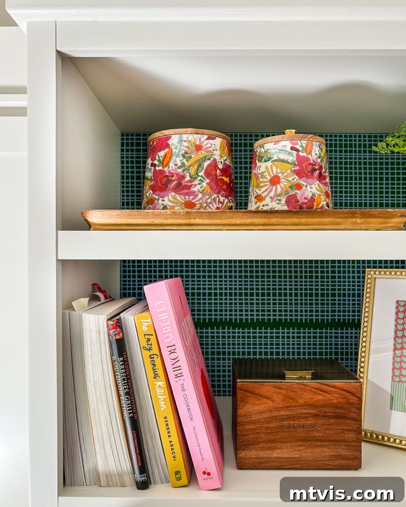 Open shelf in a butler's pantry featuring decorative wallpaper and organized items.