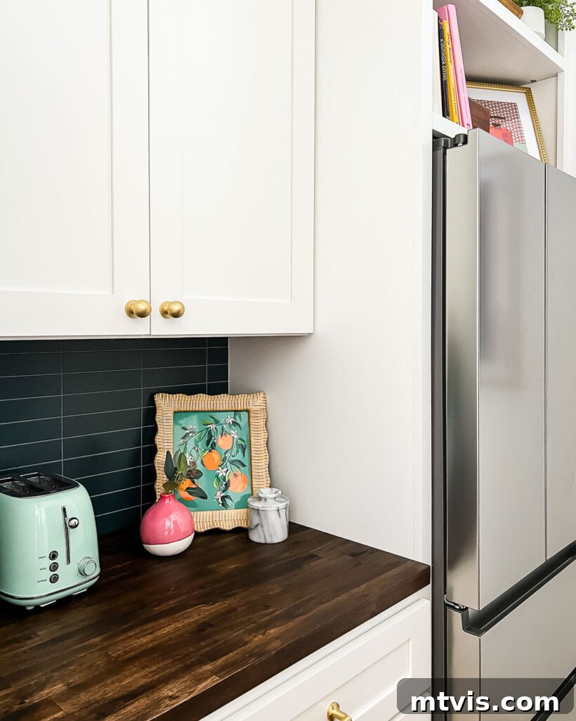 View of a colorful butler's pantry with navy blue tile, white cabinets, and carefully arranged decorative items.