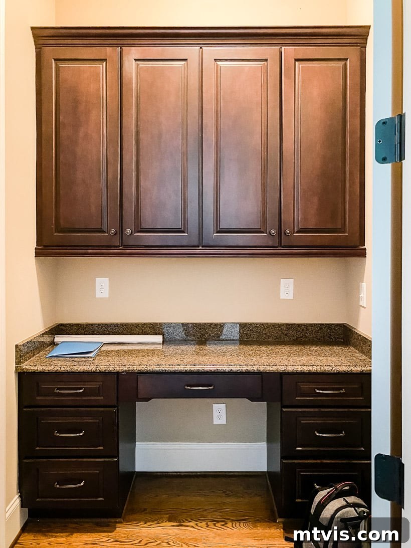 Before image of a cluttered kitchen built-in office desk area.