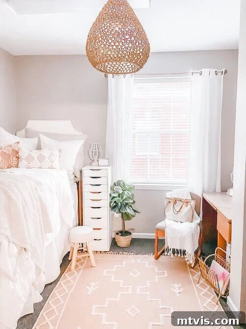 Ultimate Dorm Room Style Ideas and Shopping Sources 12 A sophisticated neutral dorm room transformed into a peach-toned haven, seamlessly integrating with the standard wood furniture. The dorm room ideas feature a modern tear-drop hanging light, ethereal sheer white curtains, a practical nightstand with nine drawers for ample storage, and a high twin bed, creating an elegant and functional living space.