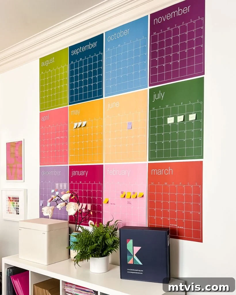 Ultimate Dorm Room Style Ideas and Shopping Sources 17 A large, reusable wall calendar with a different color for each month, ingeniously designed to function as both a practical organizer and a piece of modern artwork. It is displayed on the wall behind a short bookcase, showcasing functional and aesthetic dorm room decor.