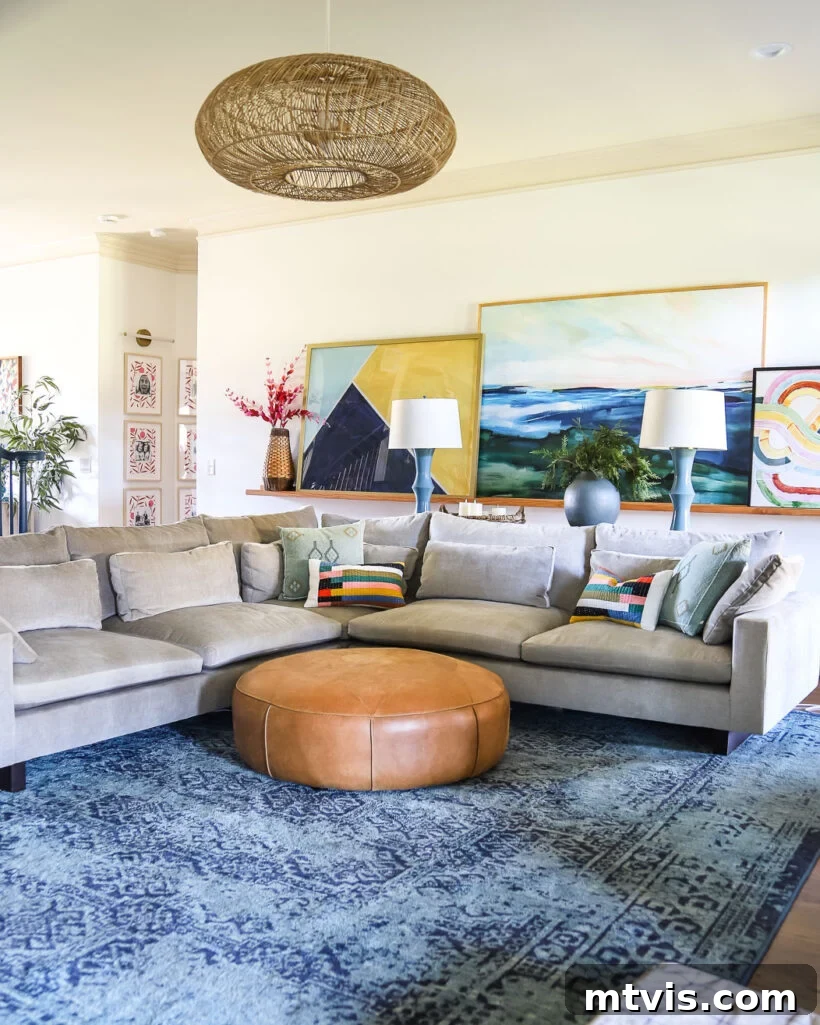 Mastering Living Room Rug Sizes 5 colorful living room with large art, round leather ottoman and large sectional sofa on large blue area rug