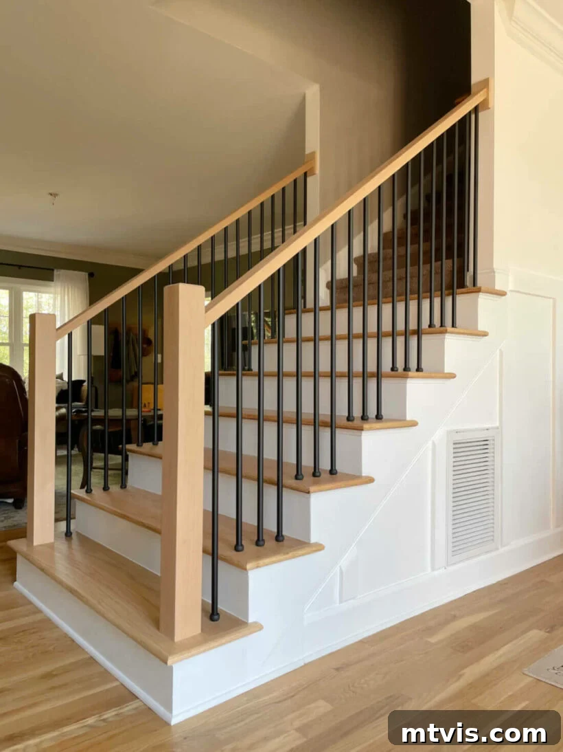 modern staircase makeover by changing the lines of the bottom step and banister with black iron