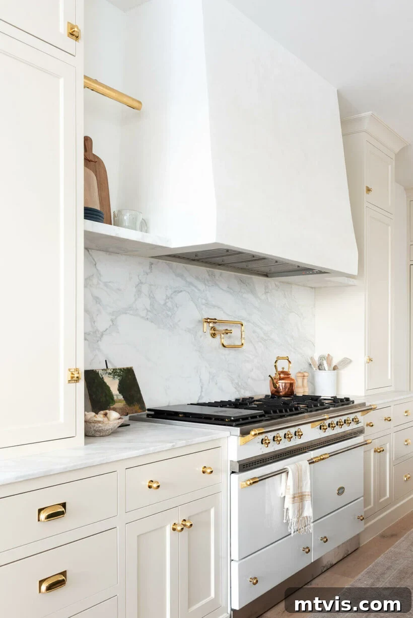 Elevate Your Kitchen with Timeless Neutral Cabinet Shades 5 Creamy White by Benjamin Moore on cabinets with white vent and marble backsplash