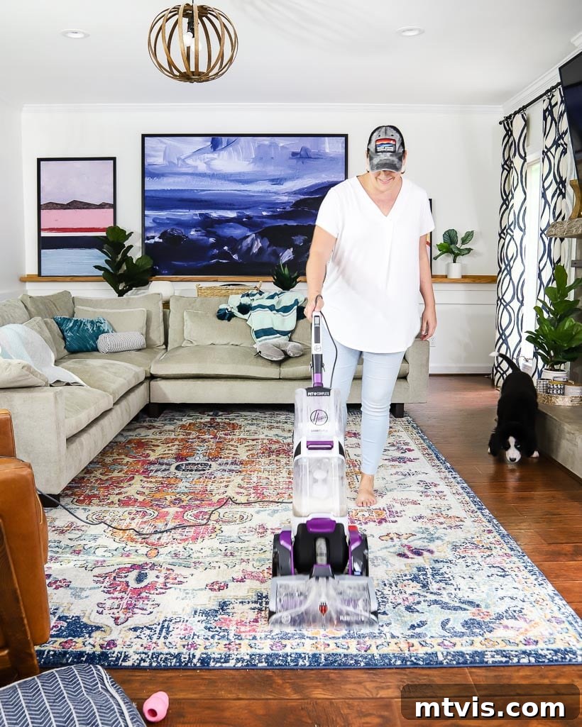 Woman cleaning area rug with a Hoover carpet cleaner, demonstrating DIY rug cleaning.