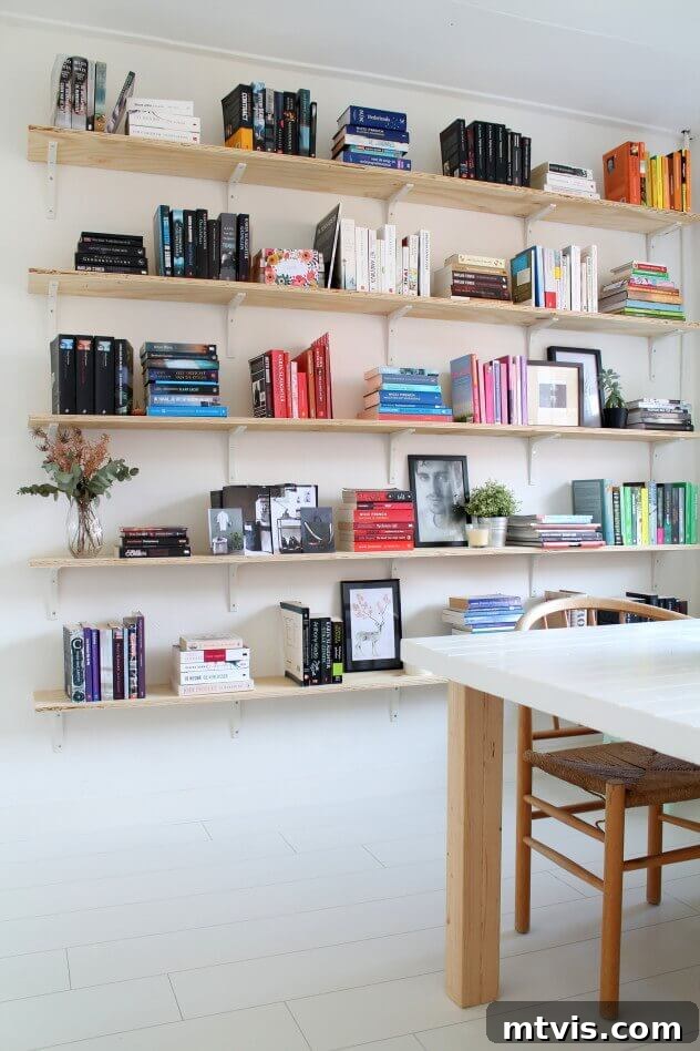 DIY Shelves Made Simple and Stylish 11 Large plywood bookcase with white brackets filling a blank dining room wall