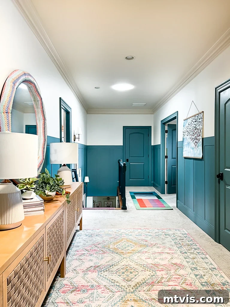 A large home's hallway with blue accent walls and a light, decorative area rug. The perfect rug enhances any space.