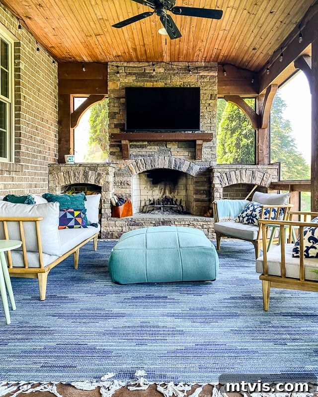 An affordable blue indoor-outdoor rug on a screened-in porch in front of a brick fireplace, perfect for durability.