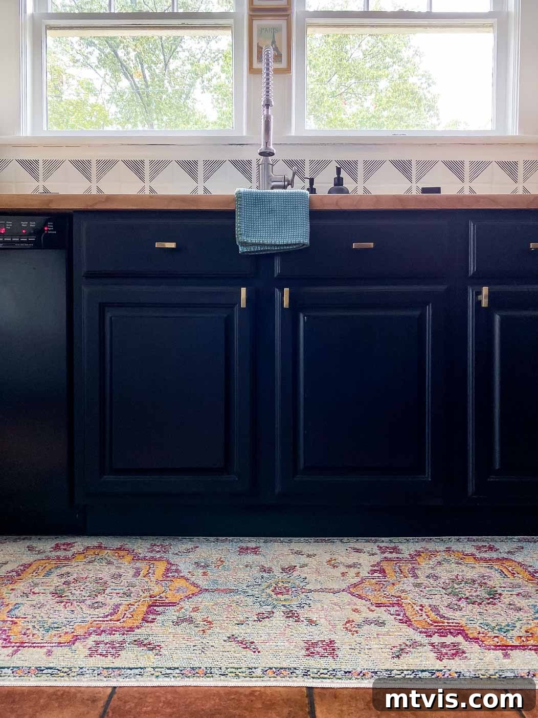 Designer Strategies for Stunning Kitchen Runner Rugs 2 A colorful medallion kitchen rug runner in front of a sink with deep blue cabinets.