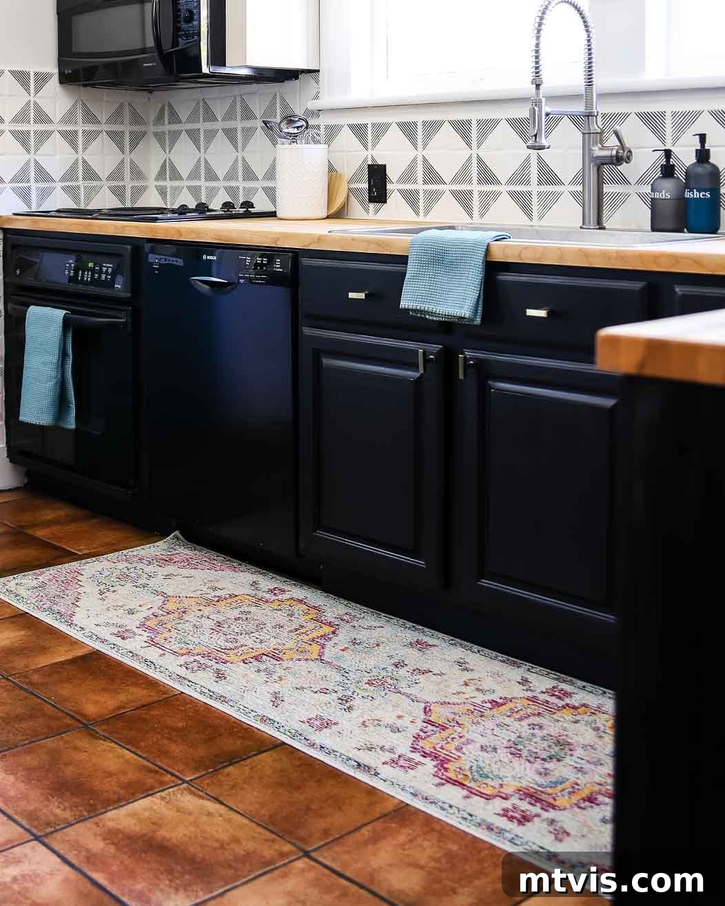 Designer Strategies for Stunning Kitchen Runner Rugs 3 A length of muted-colors medallion kitchen rug runner in a black and white kitchen.