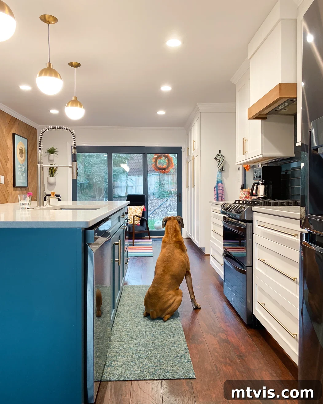 Designer Strategies for Stunning Kitchen Runner Rugs 6 A Chiliewich woven vinyl kitchen rug runner in colorful kitchen with a bright blue center island. A dog sits on the runner looking out sliding glass doors.