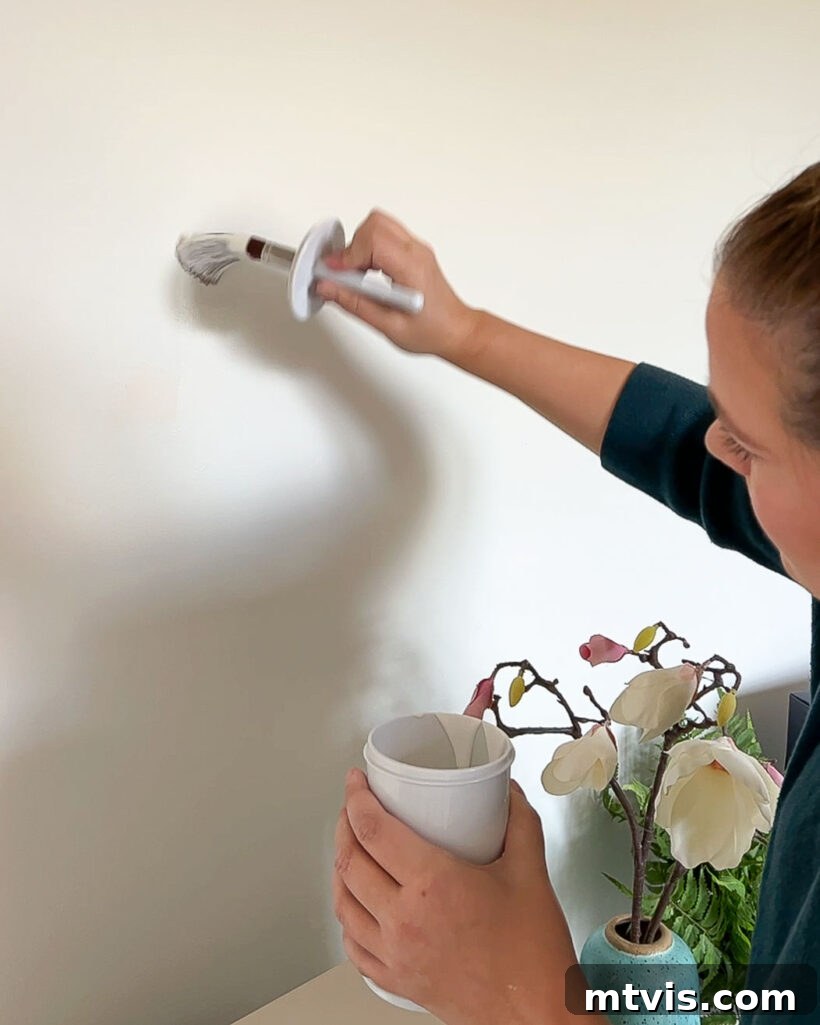 Master Wall Paint Touch Ups for a Flawless Finish 3 woman touching up paint on white wall