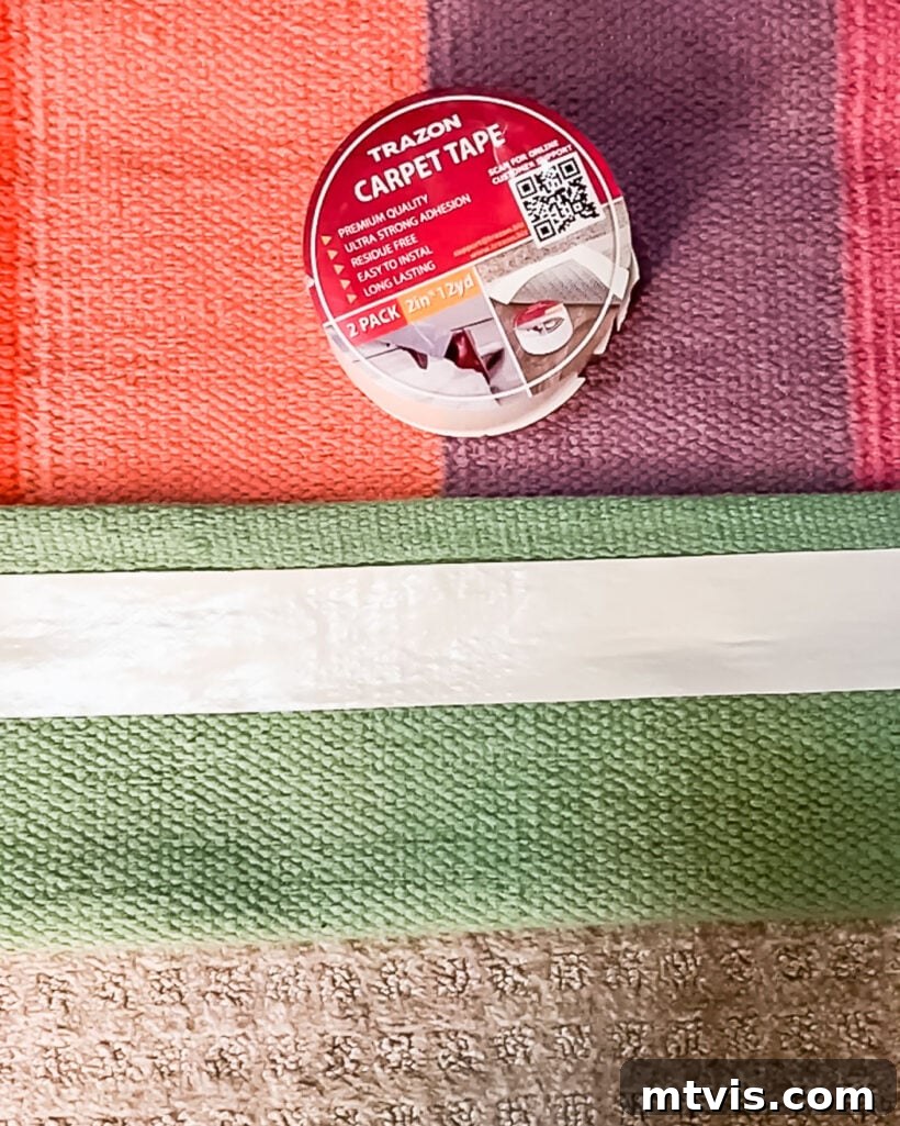 Mastering Flat Rugs Simple Solutions 5 Double-sided carpet tape applied to the edge of a rug over carpet for secure placement.