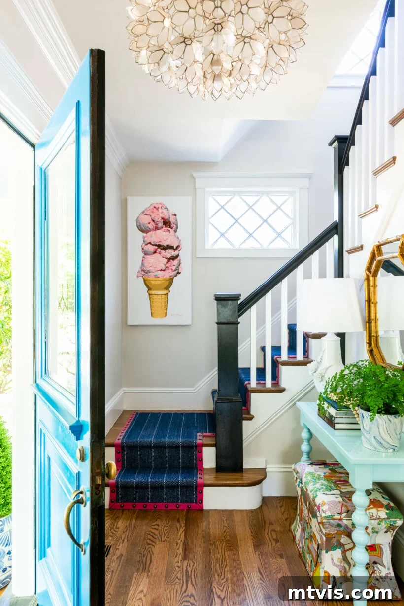 15 Stylish Stair Railing Concepts to Elevate Your Home 12 Black newel posts and handrails complement a bohemian-style foyer with interesting art and décor.