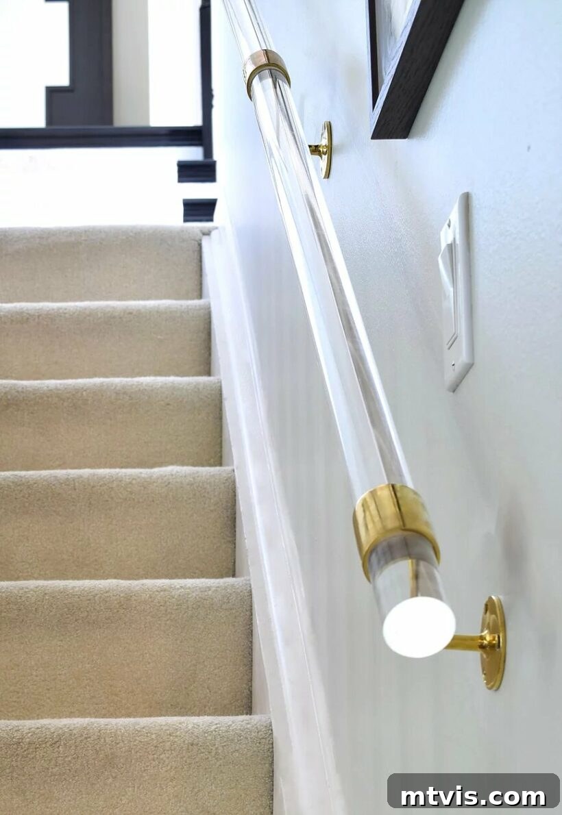 15 Stylish Stair Railing Concepts to Elevate Your Home 16 A clear Lucite handrail is extremely eye-catching and unique with gold hardware.