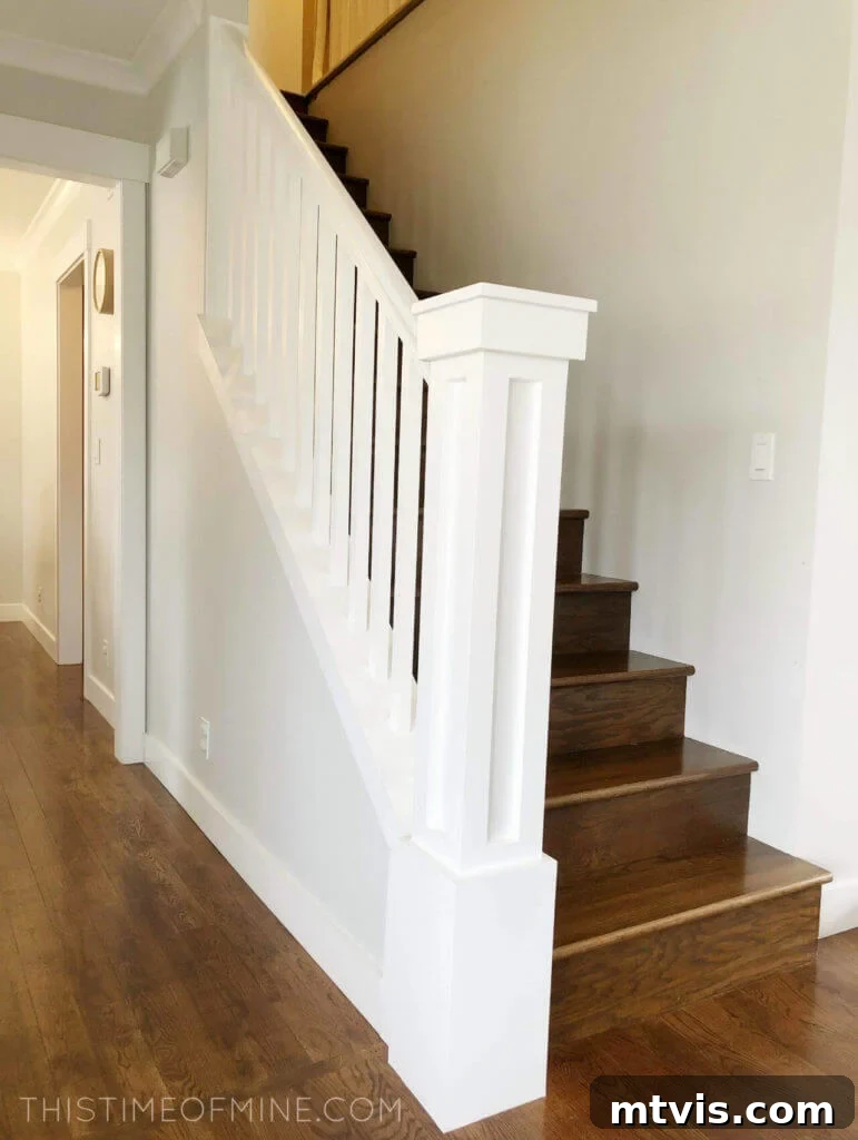 15 Stylish Stair Railing Concepts to Elevate Your Home 9 White balusters and handrails add visual interest to a wooden set of stairs.