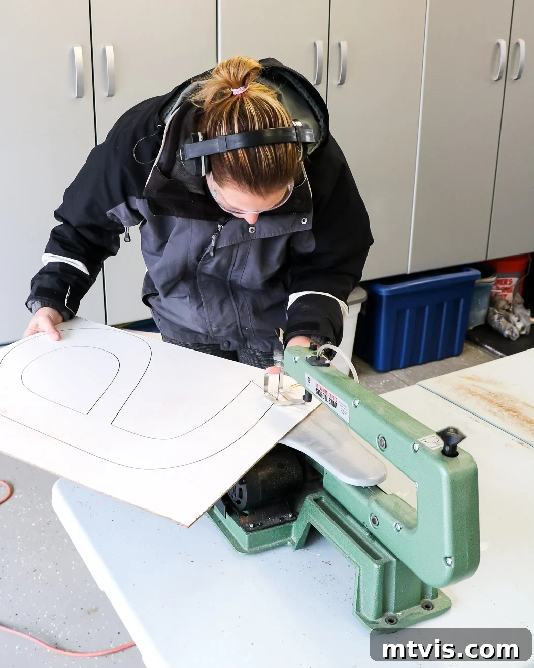 Supersize Your Walls With DIY Letters 4 Woman expertly cutting out a large DIY wall letter with a scroll saw