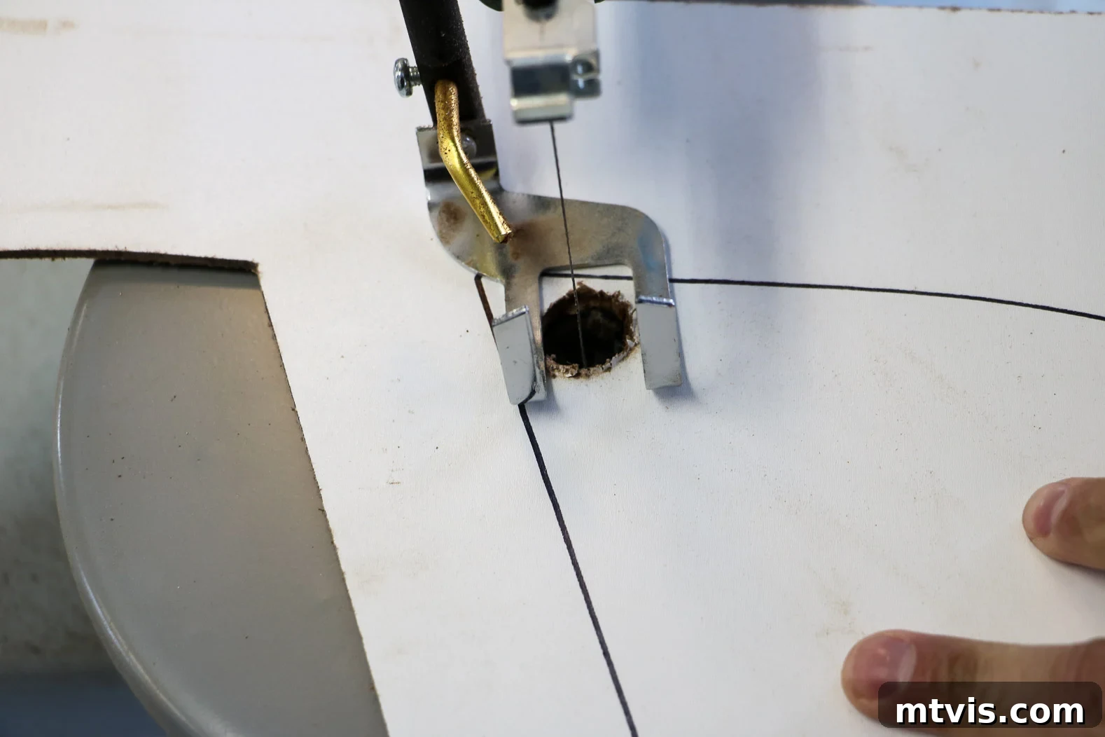 Close-up view of a scroll saw making an internal cut on a wooden letter shape