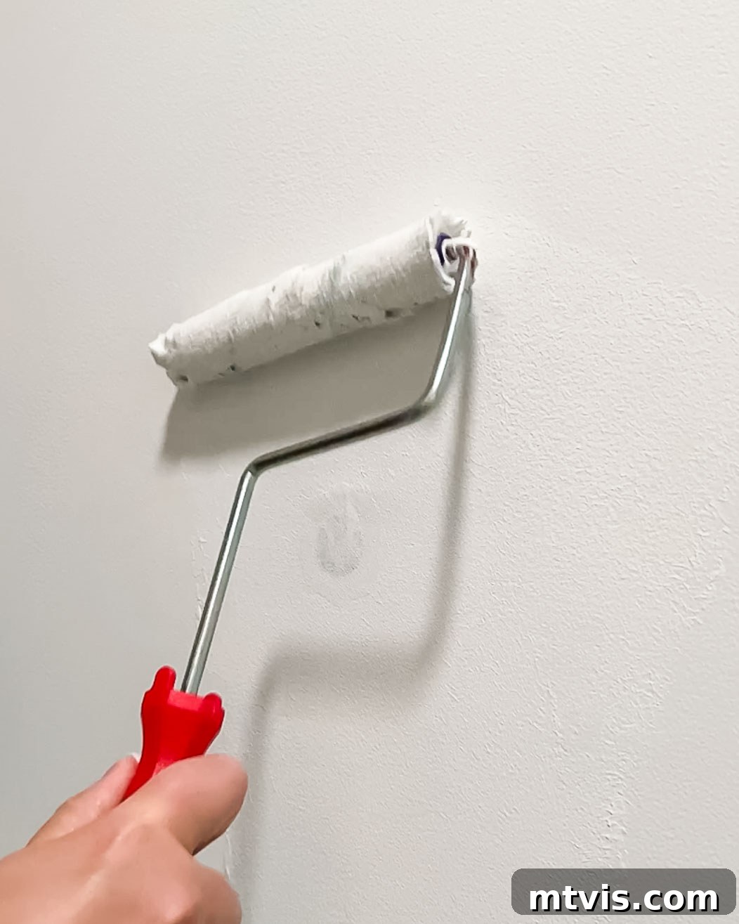 woman painting over DAP Eclipse wall repair patch