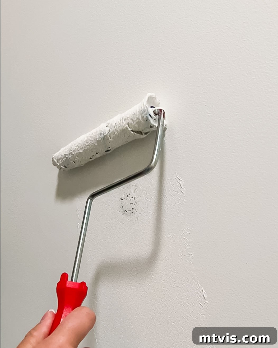 woman painting over DAP Eclipse repair patch with paint roller