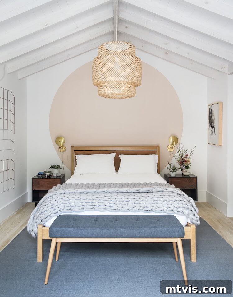 23 Ingenious DIY Wall Art Projects 9 A serene white room featuring a blush pink circle mural painted elegantly behind a light wood slatted bed, creating a soft focal point.