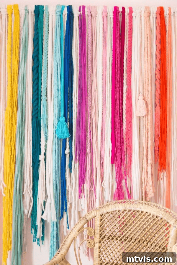 23 Ingenious DIY Wall Art Projects 10 A vibrant and textured yarn wall hanging, artfully crafted in a spectrum of rainbow colors, adding a playful touch to any space.