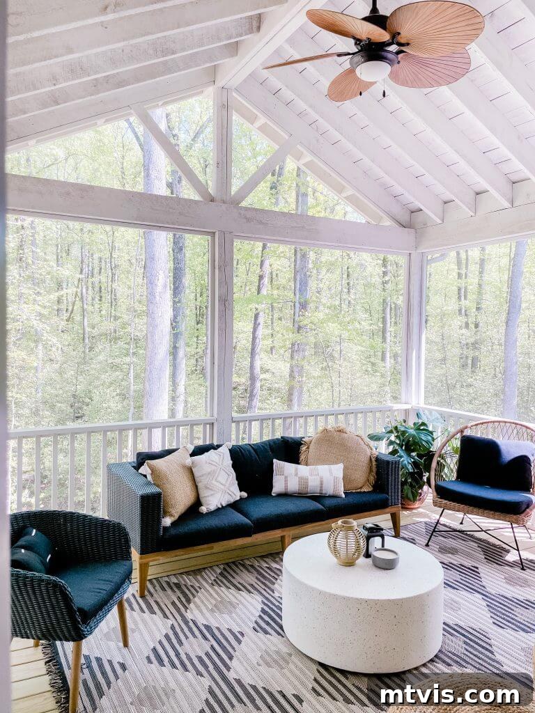 Screened Porch Retreats: Designs for Blissful Outdoor Living 10 One screened-in porch idea uses a wicker ceiling fan and black and white decor, surrounded by trees. A round white coffee table provides a central focus.