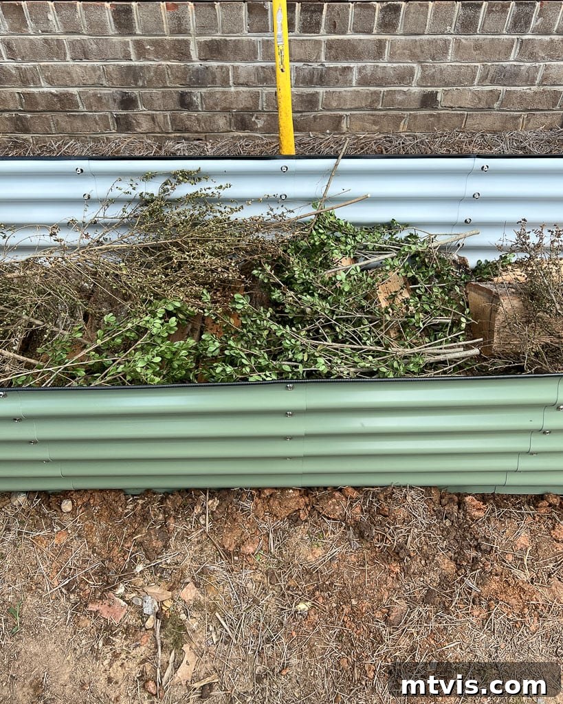 Image demonstrating the process of filling a Vego garden bed using the Hugelkultur method, showing layers of organic materials.
