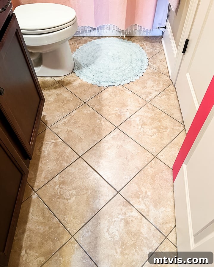 15+ Ingenious DIY Bathroom Renovation Ideas That Won't Break the Bank 18 outdated brown bathroom floor tile before applying stickers