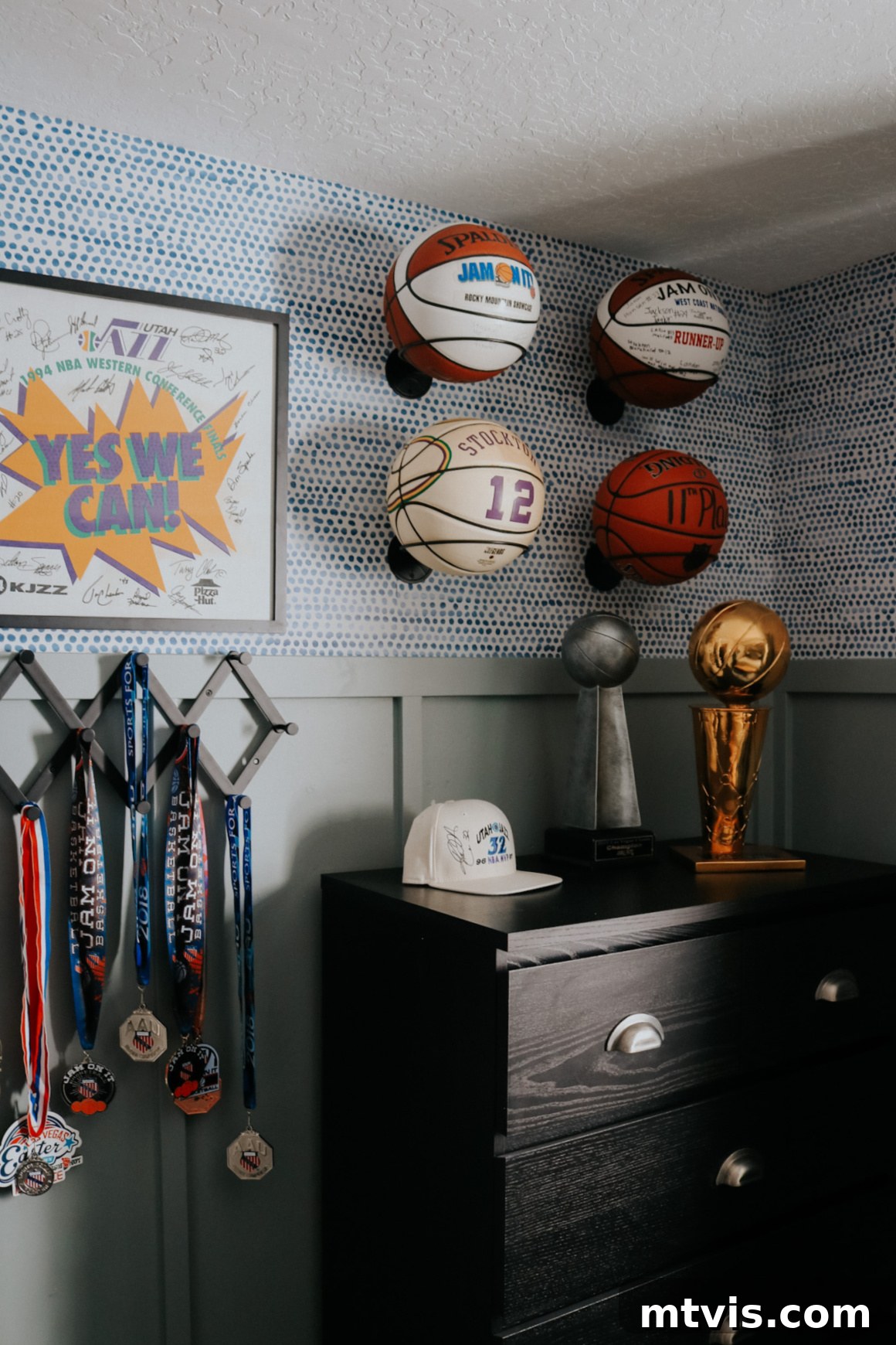 25 Creative Bedroom Transformations for Teenagers 23 Basketballs as used wall art in teen boy's bedroom above a dark dresser and next to hanging awards.