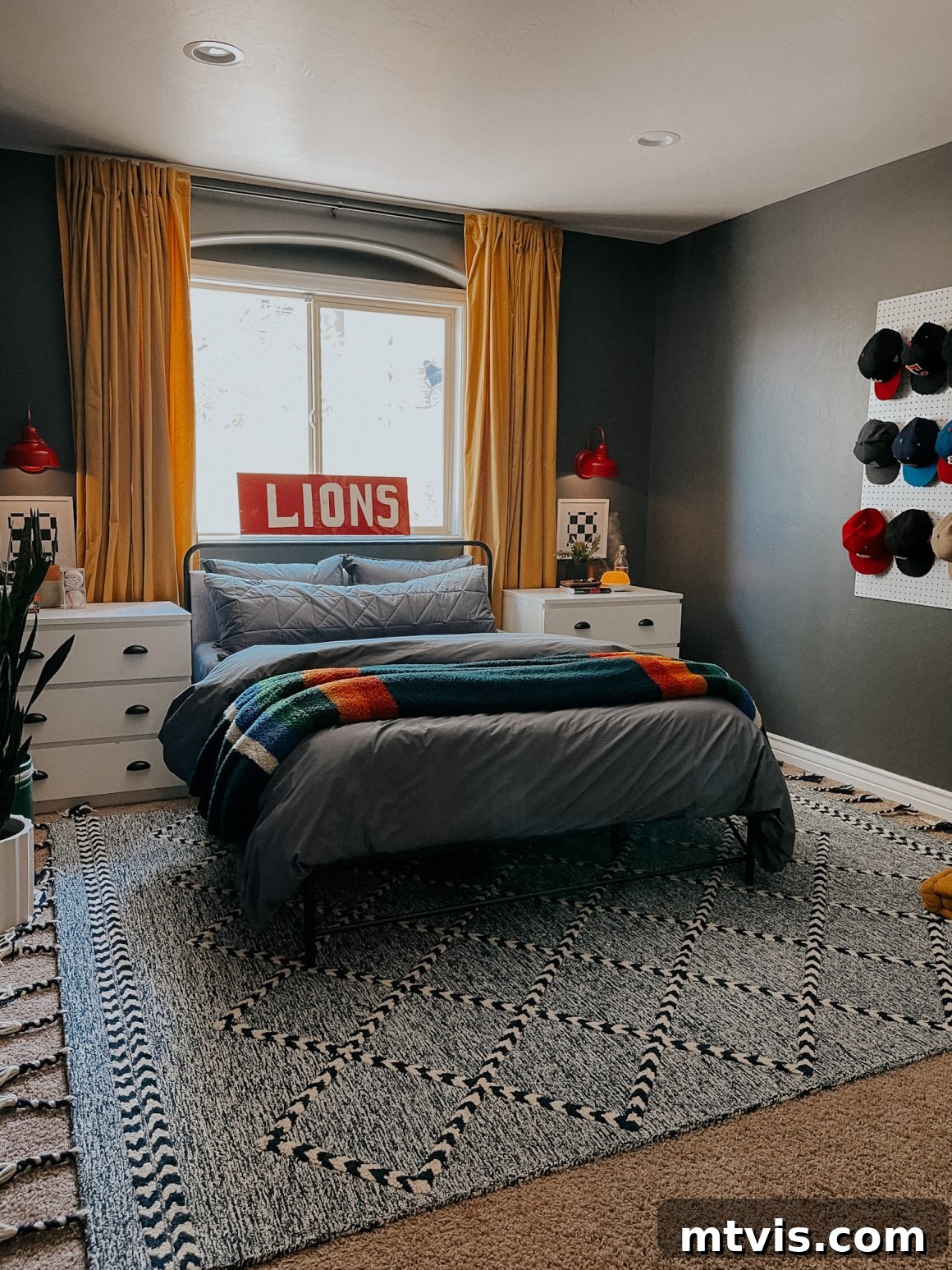 25 Creative Bedroom Transformations for Teenagers 27 A cozy teen boy bedroom using light and dark colors, white dressers as nightstands, and a pegboard of baseball hats as wall art.