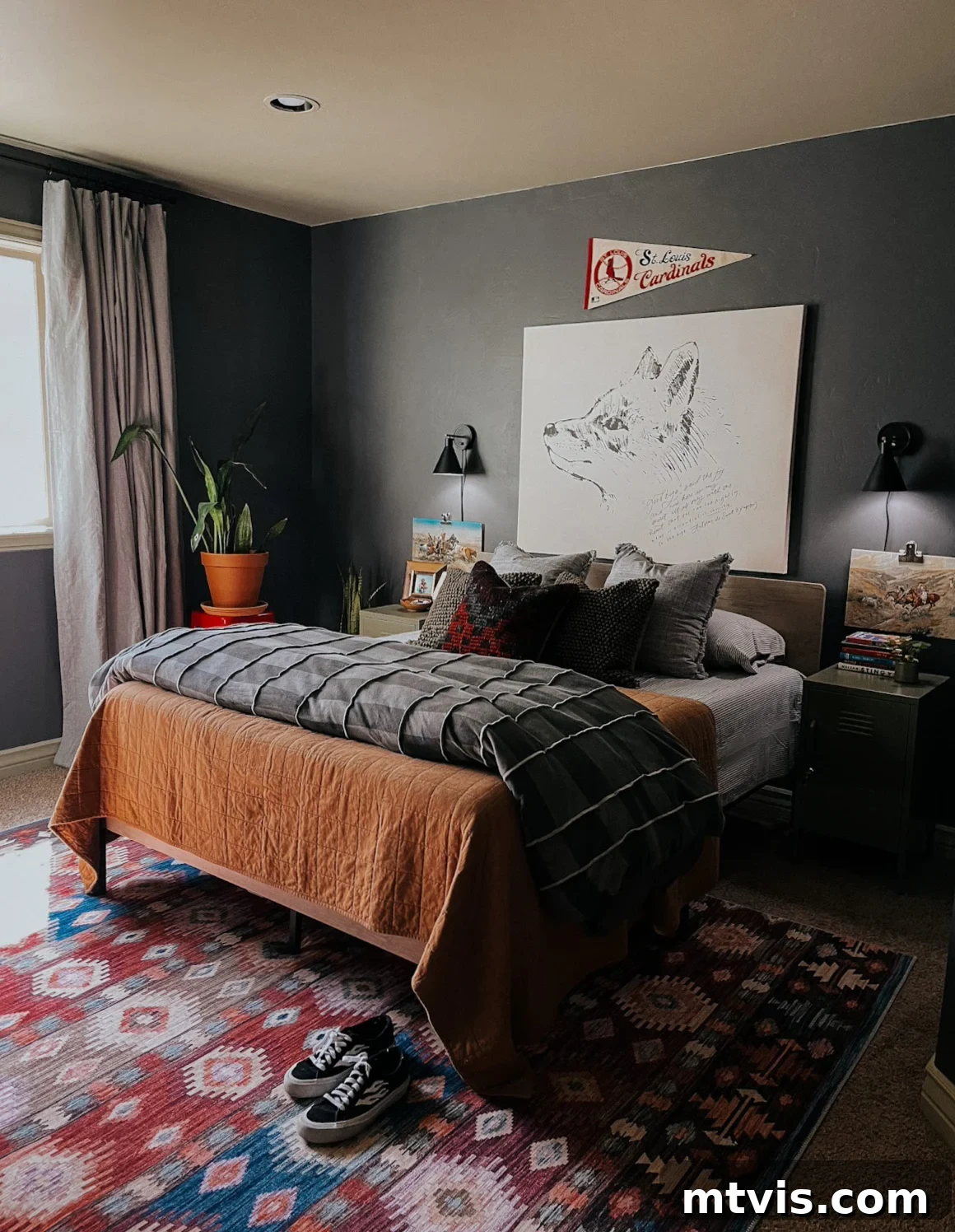 25 Creative Bedroom Transformations for Teenagers 29 A dark grey boy's bedroom with layered, textured bedding, a potted plant, and large line drawing of a dog above the bed.