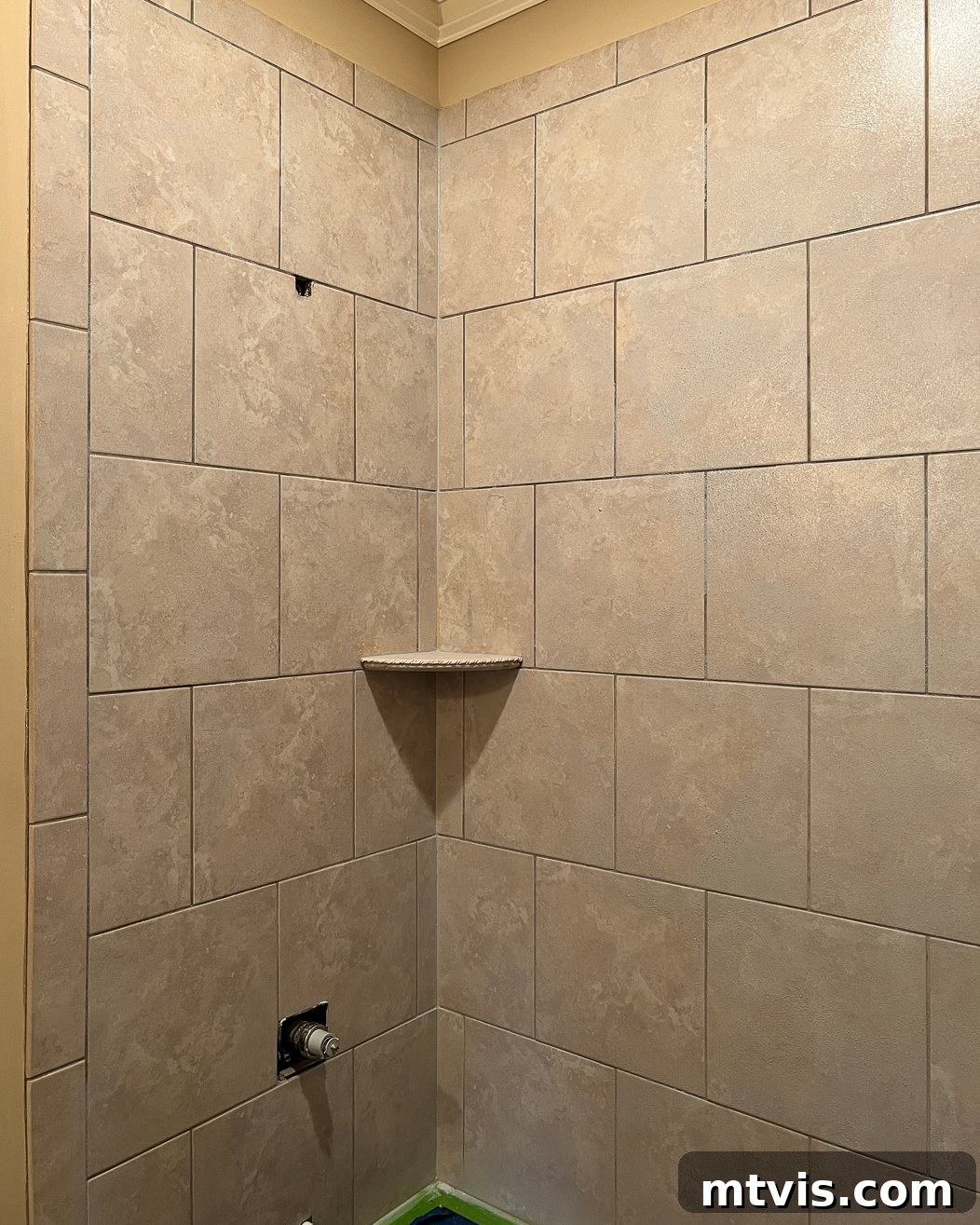 Tile shower wall primed with Eco Prim Grip, showing the slightly hazy, gritty surface ready for new tile installation