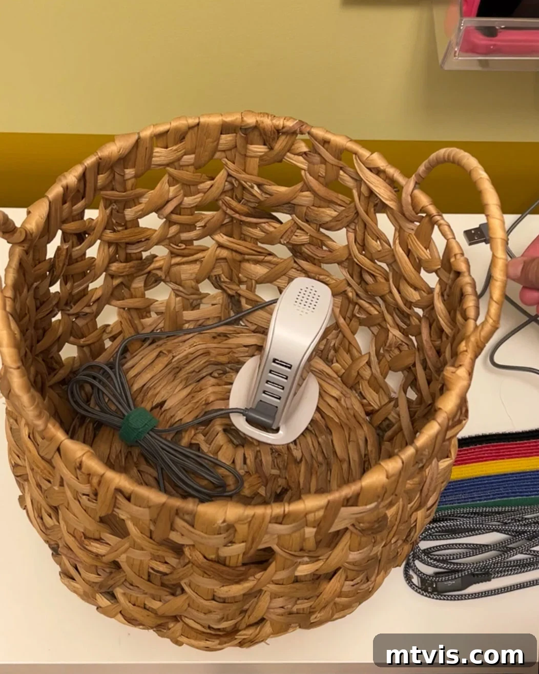 USB charging tower placed inside a woven basket for hidden cord management