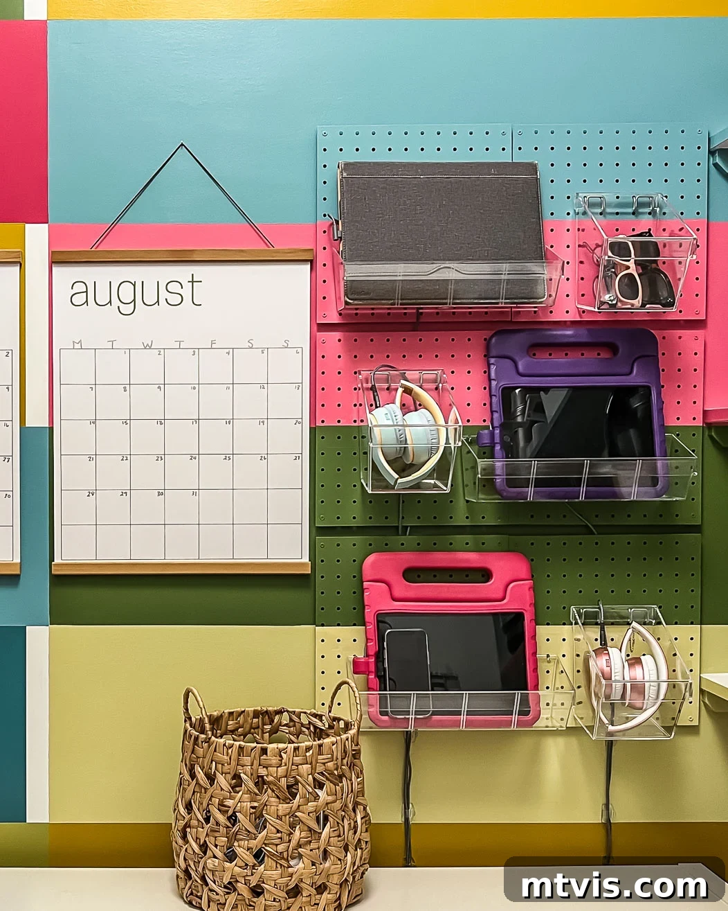 Completed family charging station on a wall-mounted pegboard with various electronic devices in acrylic bins