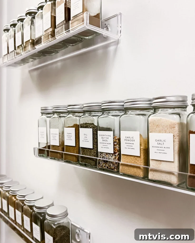 Thrifty Pantry Transformation 9 Wall-mounted acrylic spice shelves with uniformly labeled spice jars in a clean pantry