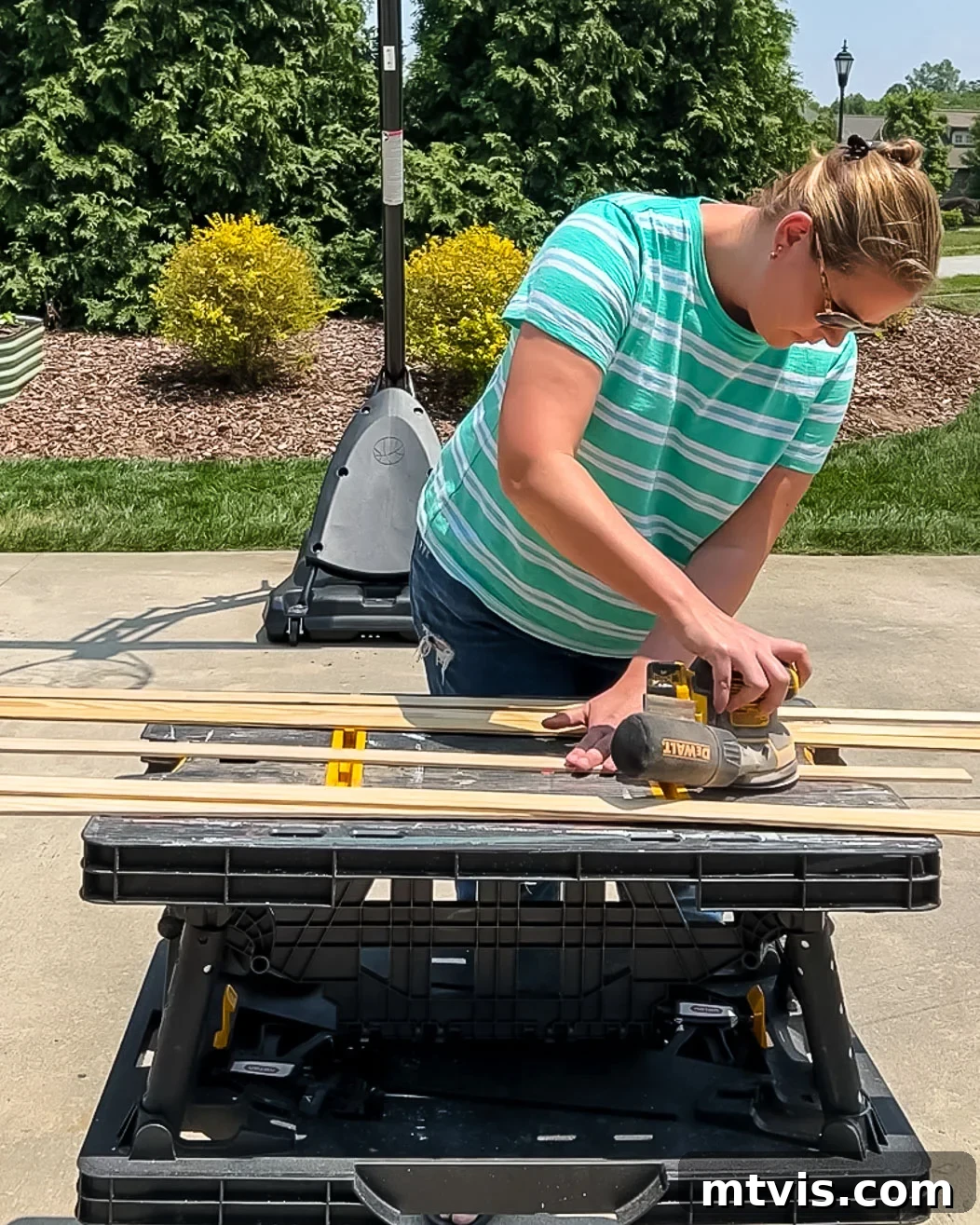 Woman sanding wooden lattice strips smooth after applying wood filler, preparing them for painting or staining for magnetic poster hangers.