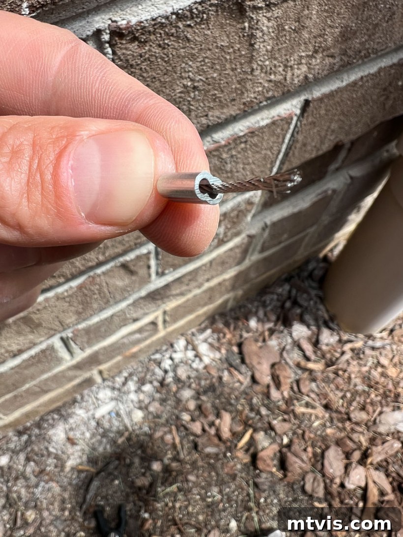 Close-up of wire rope being threaded through an aluminum ferrule, a key step for DIY trellis