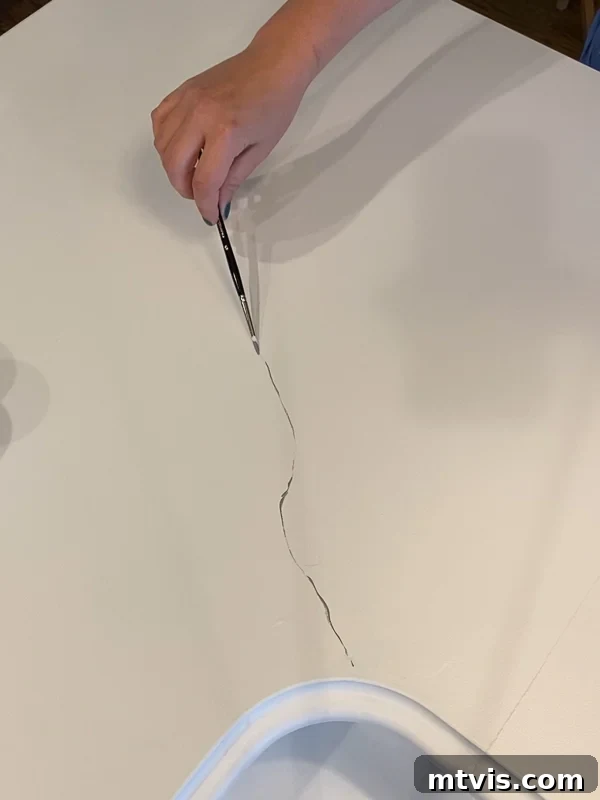 Painted Countertops The Long-Term Review 3 photo of woman painting grey veins on countertops to look like marble