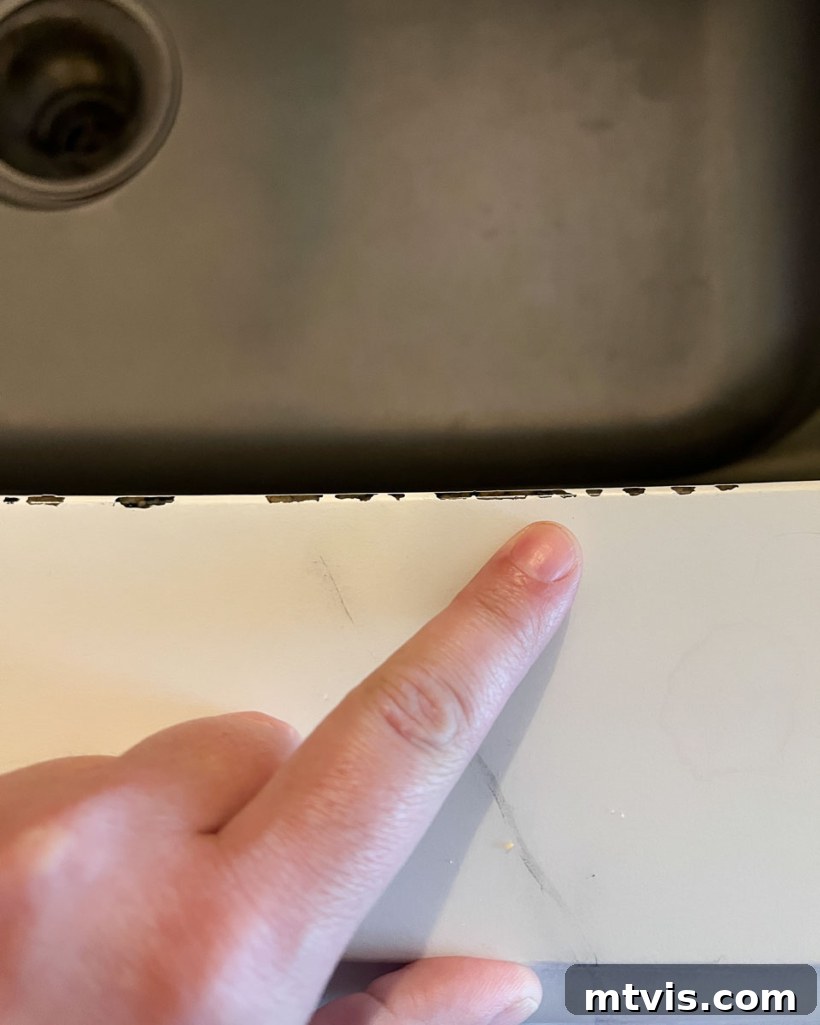 Painted Countertops The Long-Term Review 10 photo showing chipped countertop paint along the edge of an under-mount sink